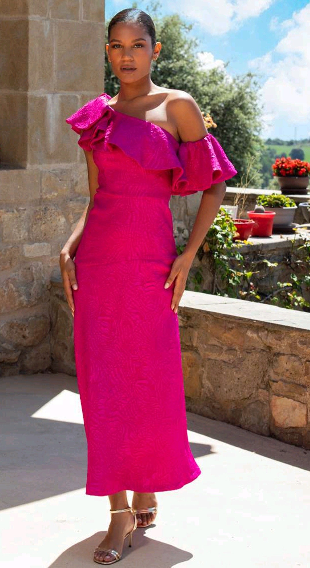 vestido invitada fucsia Betzzia escote asimétrico volante